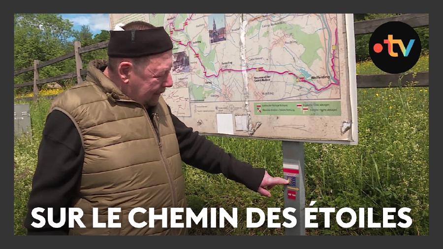 Mann erklärt Bedeutung von Sternenweg Symbol an Schilderpfosten